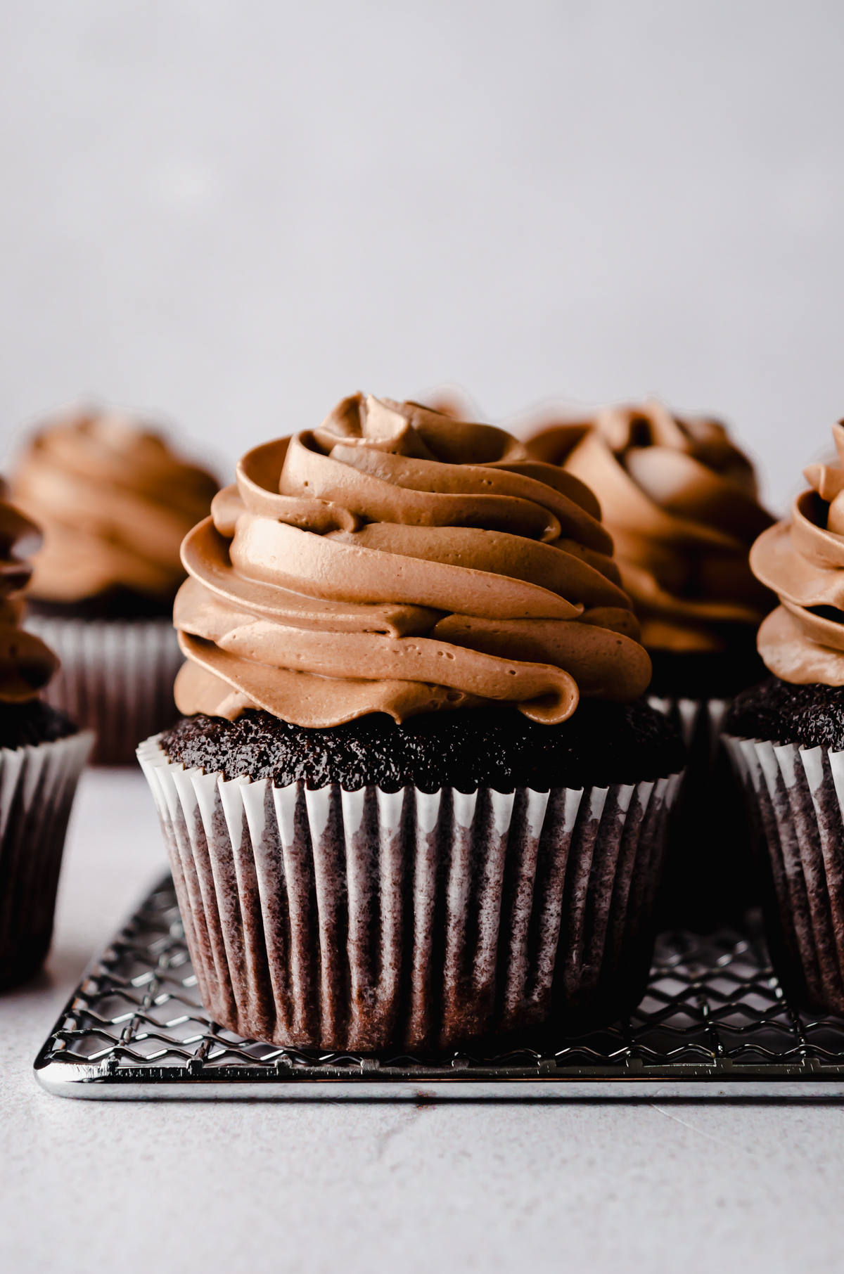 Chocolate cupcakes with chocolate Swiss meringue buttercream piped on top.