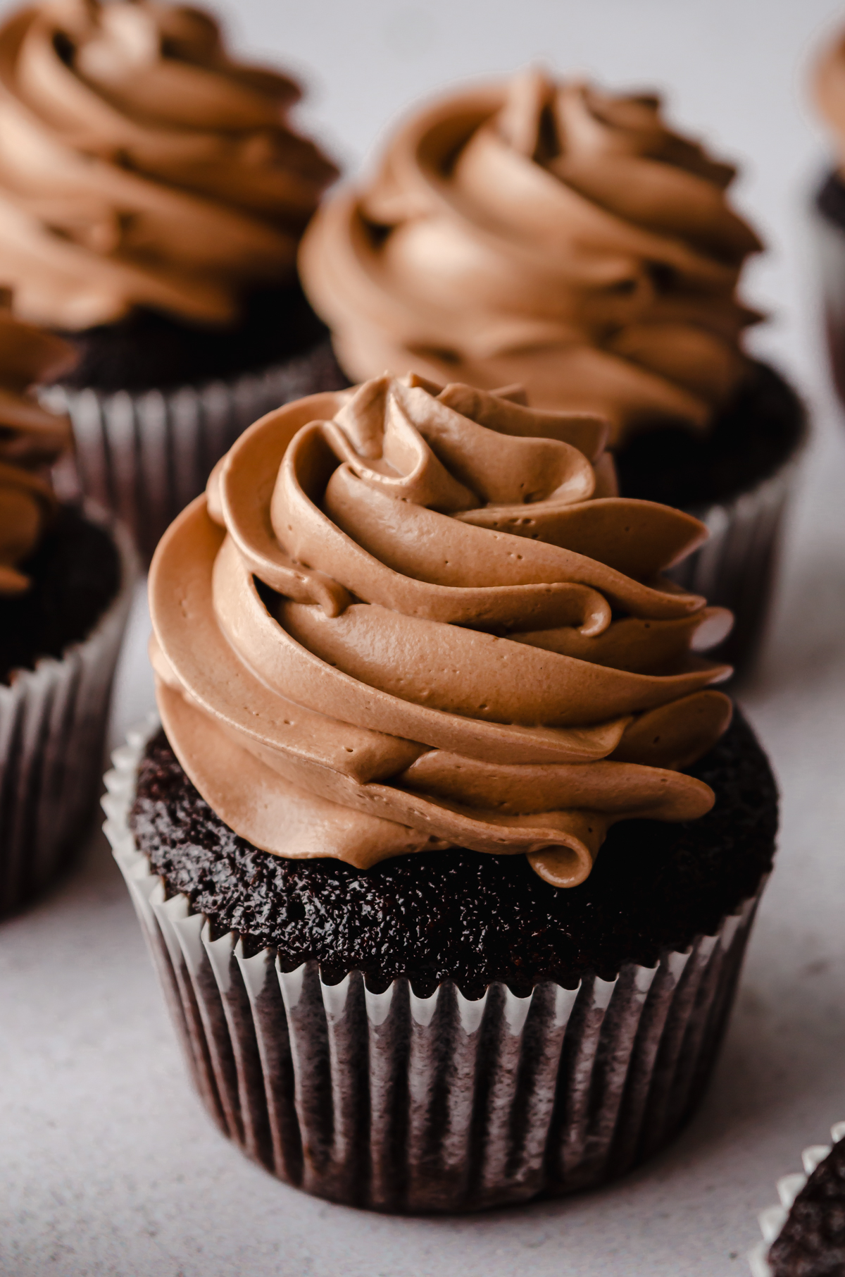 Chocolate cupcakes with chocolate Swiss meringue buttercream piped on top.