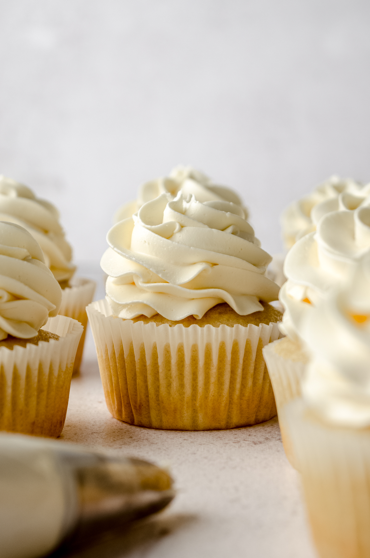 Vanilla cupcakes with a swirl of Swiss meringue buttercream piped on top.