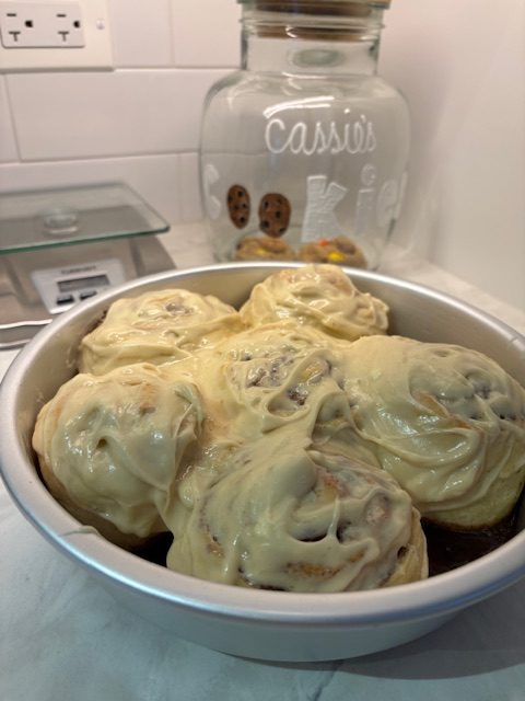 A pan of cinnamon rolls on a kitchen counter.