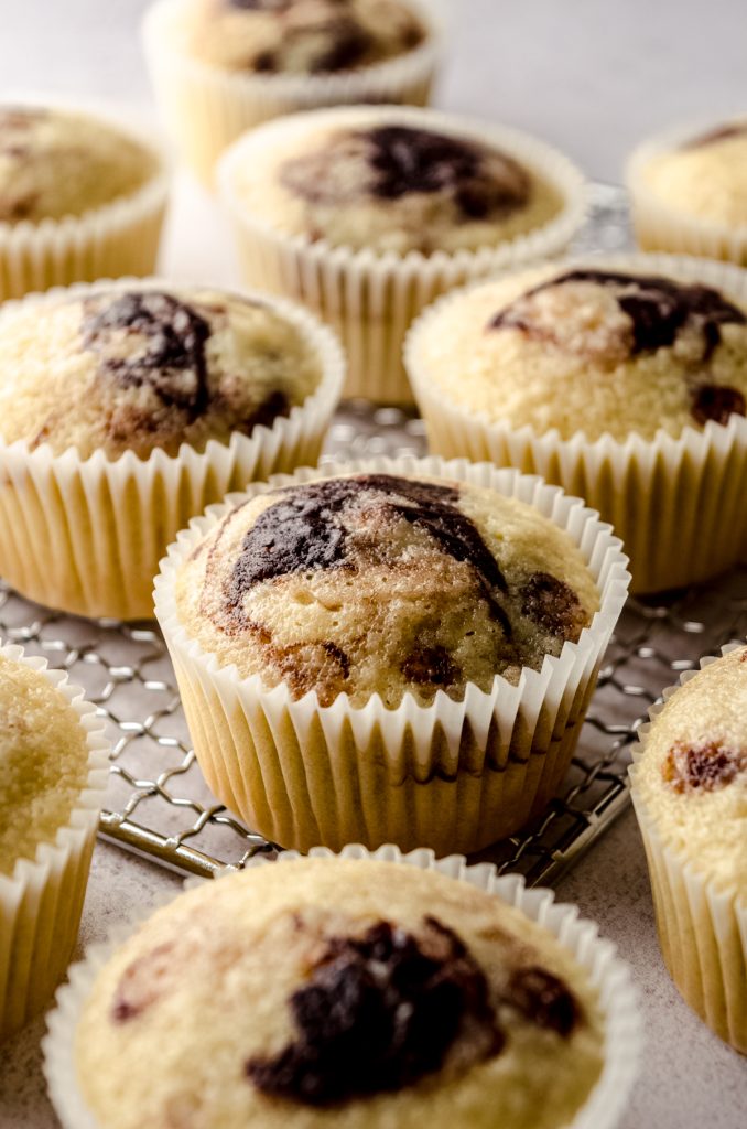 Unfrosted marble cupcakes sitting on a cooling rack.