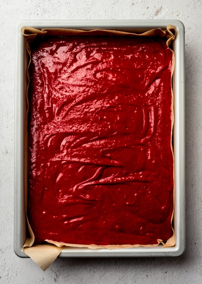 Aerial photo of a red velvet sheet cake batter in a baking pan.