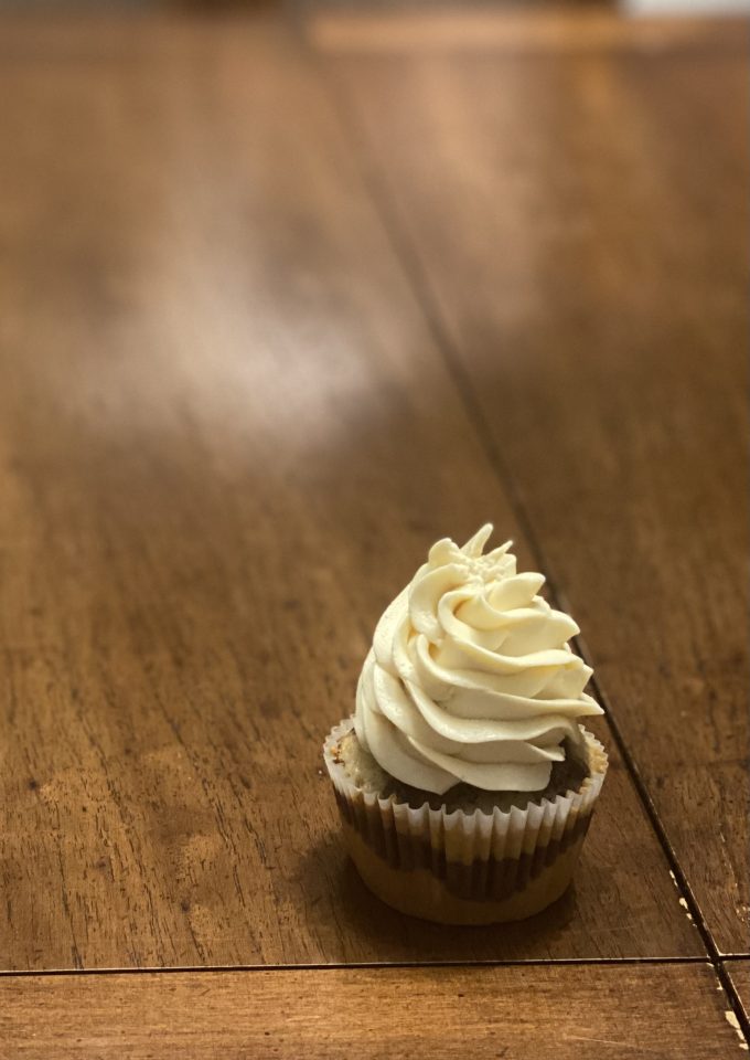 A cupcake with a Swiss meringue buttercream swirl on top.