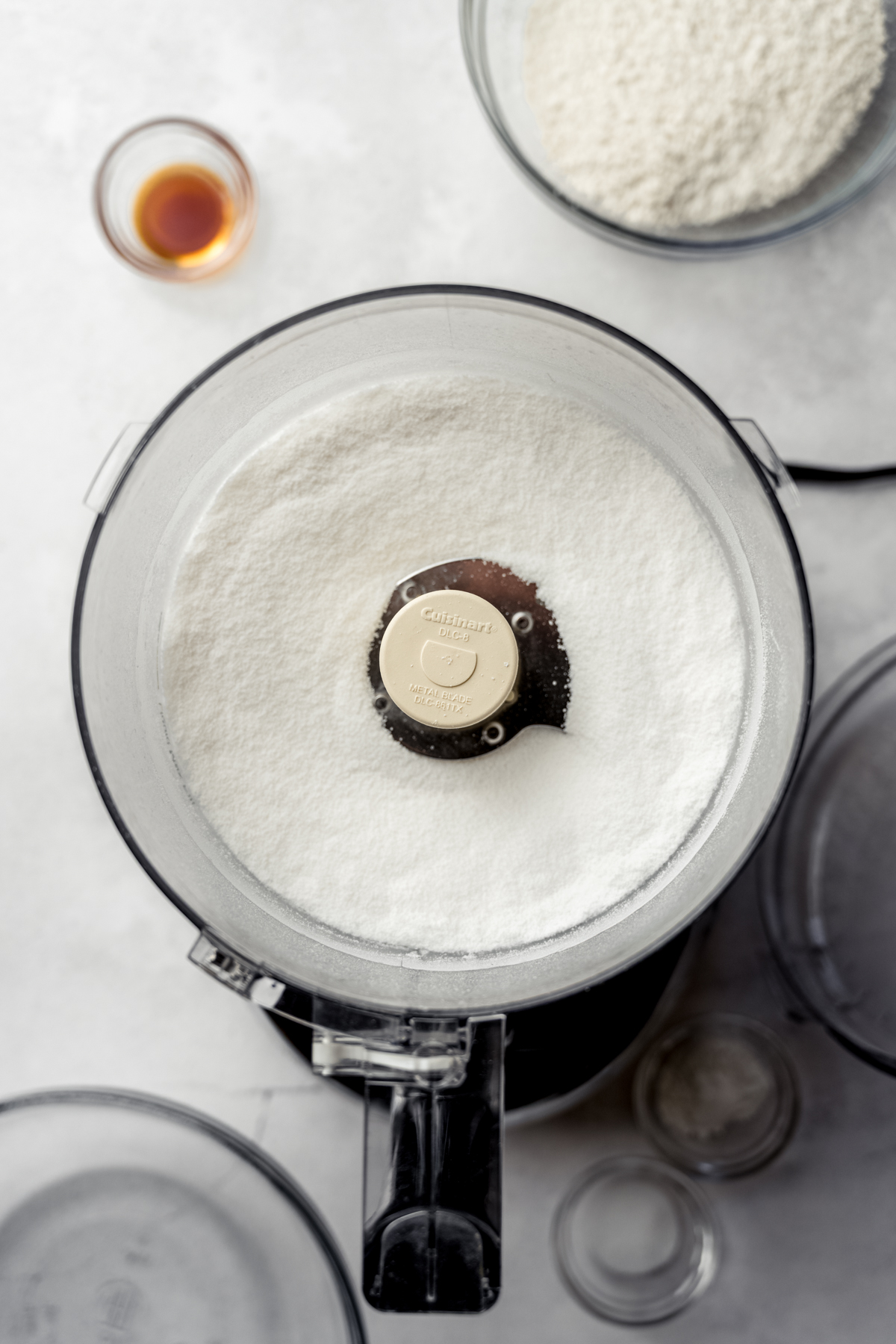 Aerial photo of the drum of a food processor with sugar in it.