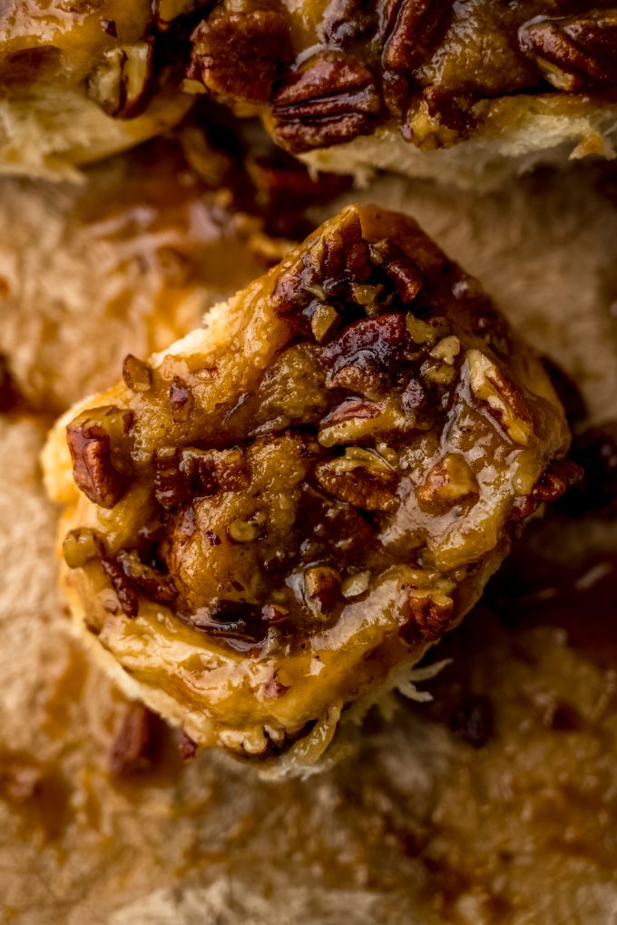 Aerial photo of a sticky bun on a sheet of parchment paper.