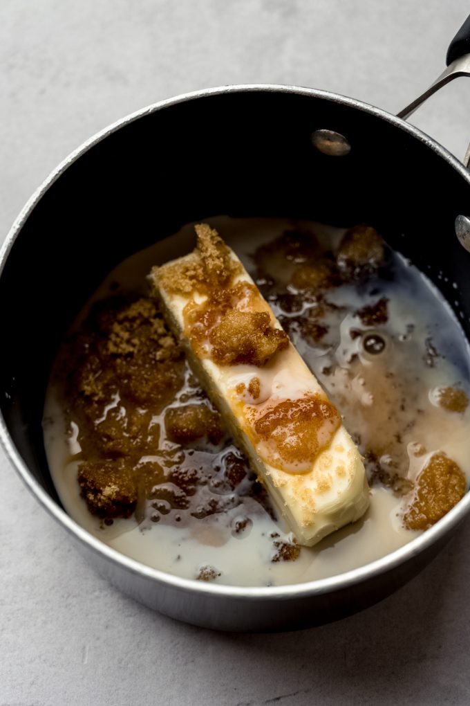 A saucepan with butter, sugar, and milk in it to make a maple caramel sauce for sticky buns.