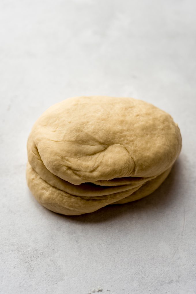 A bolus of sticky bun dough on a surface.