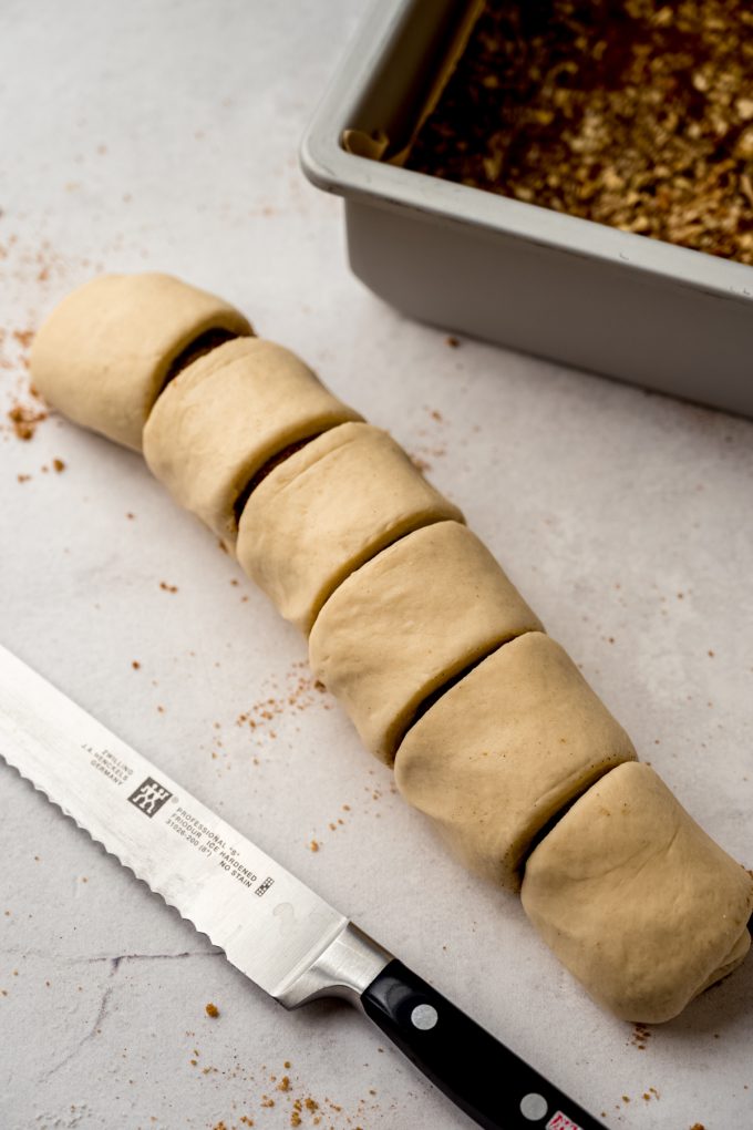 A log of rolled dough sliced into portions to make sticky buns.