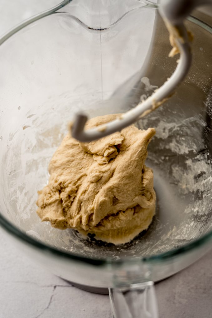 A ball of yeast dough in the bowl of a mixer before getting kneaded by hand.