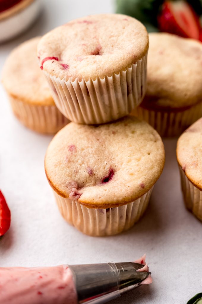 Strawberry cupcakes on a surface before getting frosted.