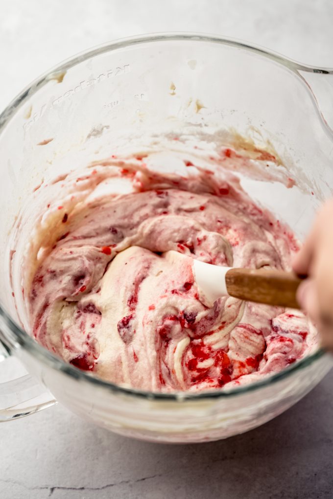 The batter for strawberry cupcakes in a large bowl with a spatula.