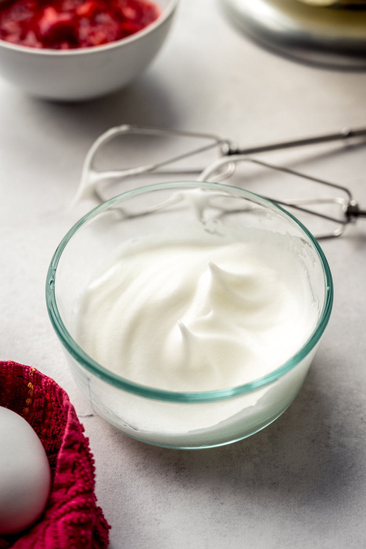 A small bowl of egg whites whipped to medium peaks.