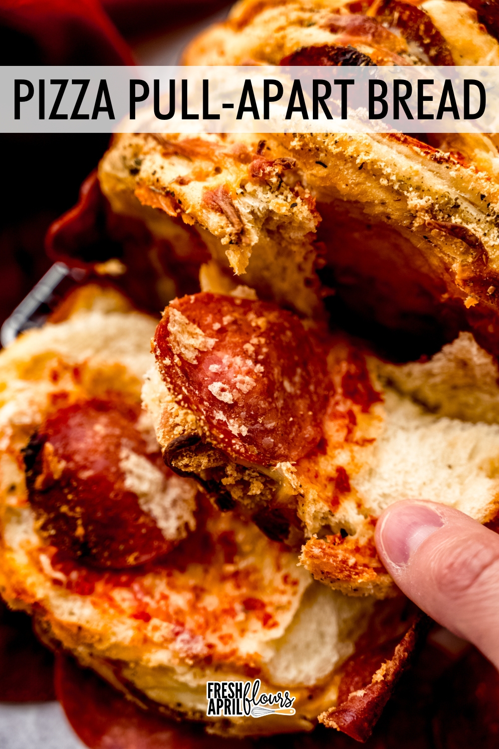 This pizza pull-apart bread is a soft, seasoned yeast bread layered with pizza sauce, shredded cheese, and pepperoni. via @frshaprilflours