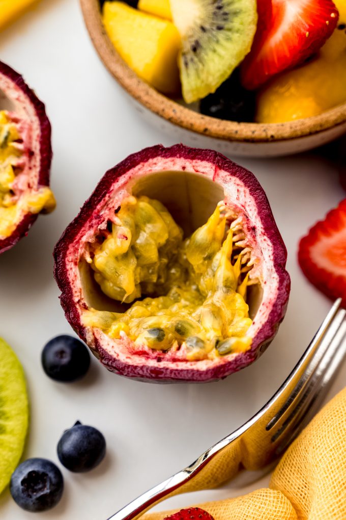 Aerial photo of a halved passion fruit on a surface.
