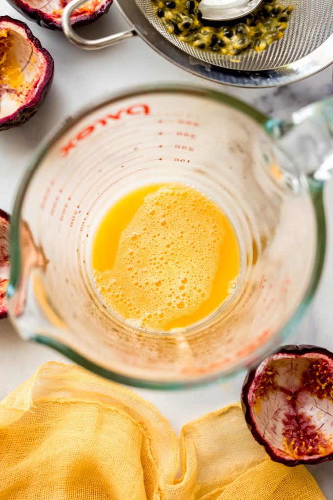 Passion fruit juice in a glass measuring cup.