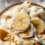 A photo of a spoon with a bite of banana pudding on it.