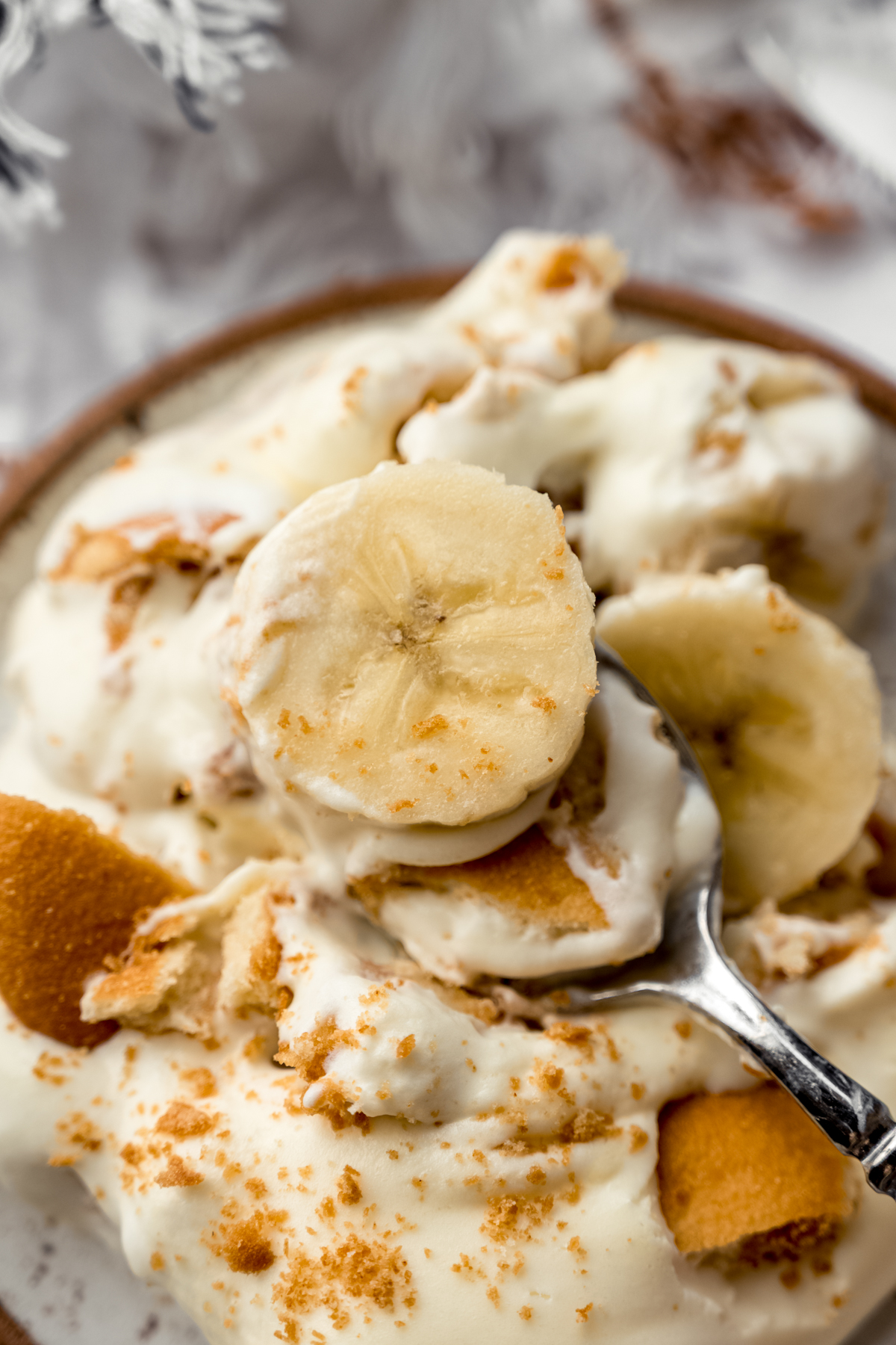 A photo of a spoon with a bite of banana pudding on it.