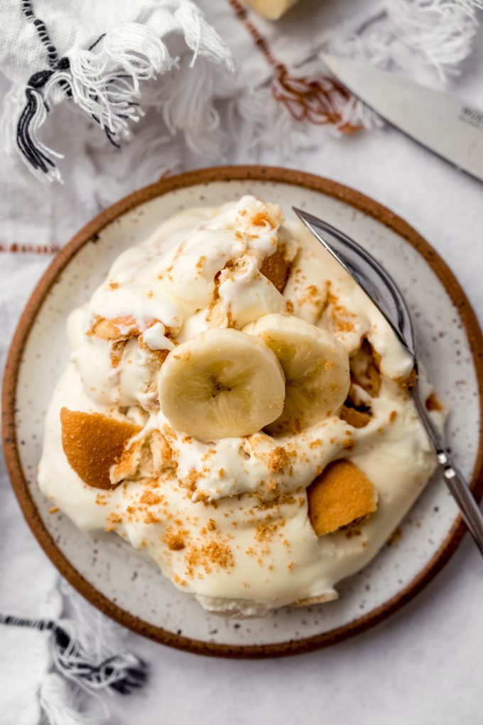 Aerial photo of a serving of banana pudding on a plate with a spoon.