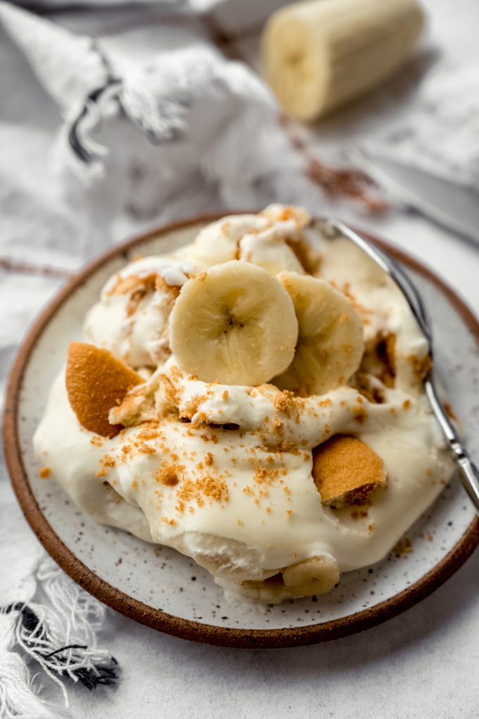 A serving of banana pudding on a plate with a spoon.