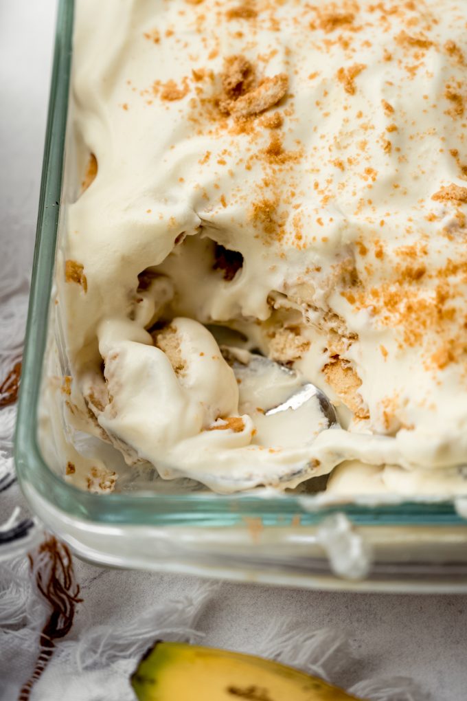 Aerial photo of a dish of banana pudding with a large serving spoon in it.