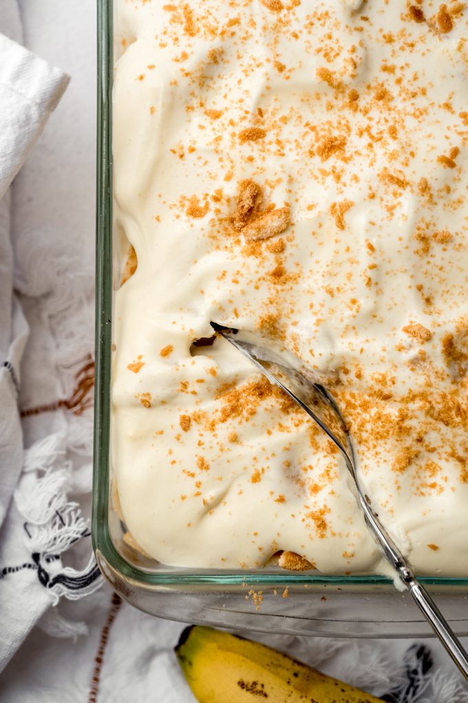 Aerial photo of a dish of banana pudding with a large serving spoon in it.