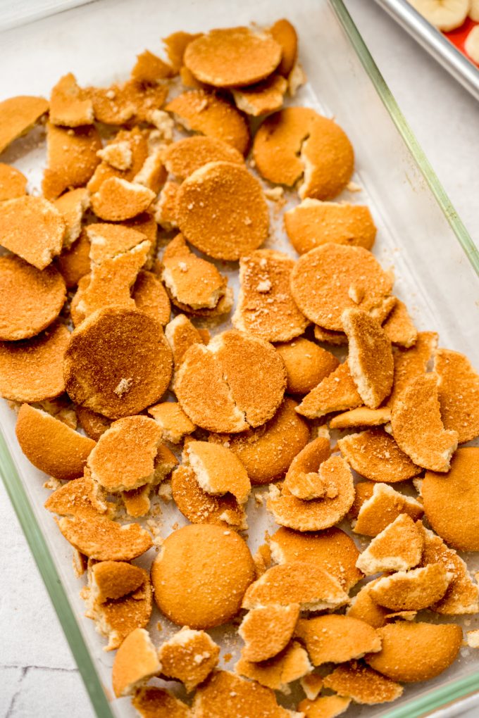 Crushed Nilla Wafers lining the bottom of a baking dish to make banana pudding.