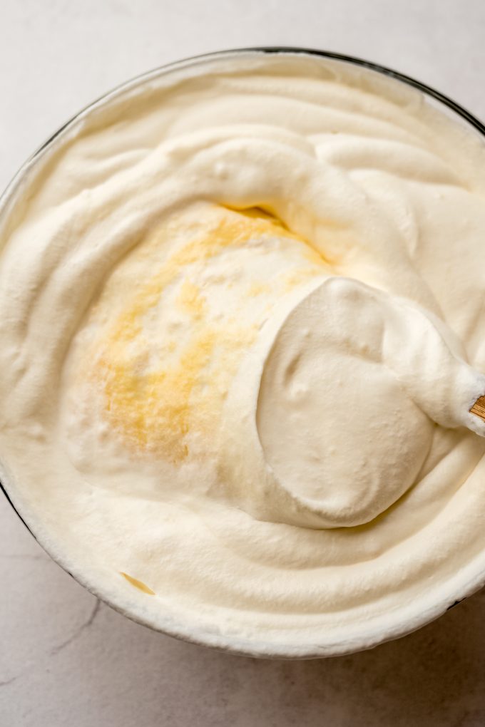 Aerial photo of someone stirring a bowl of pudding and whipped cream together.