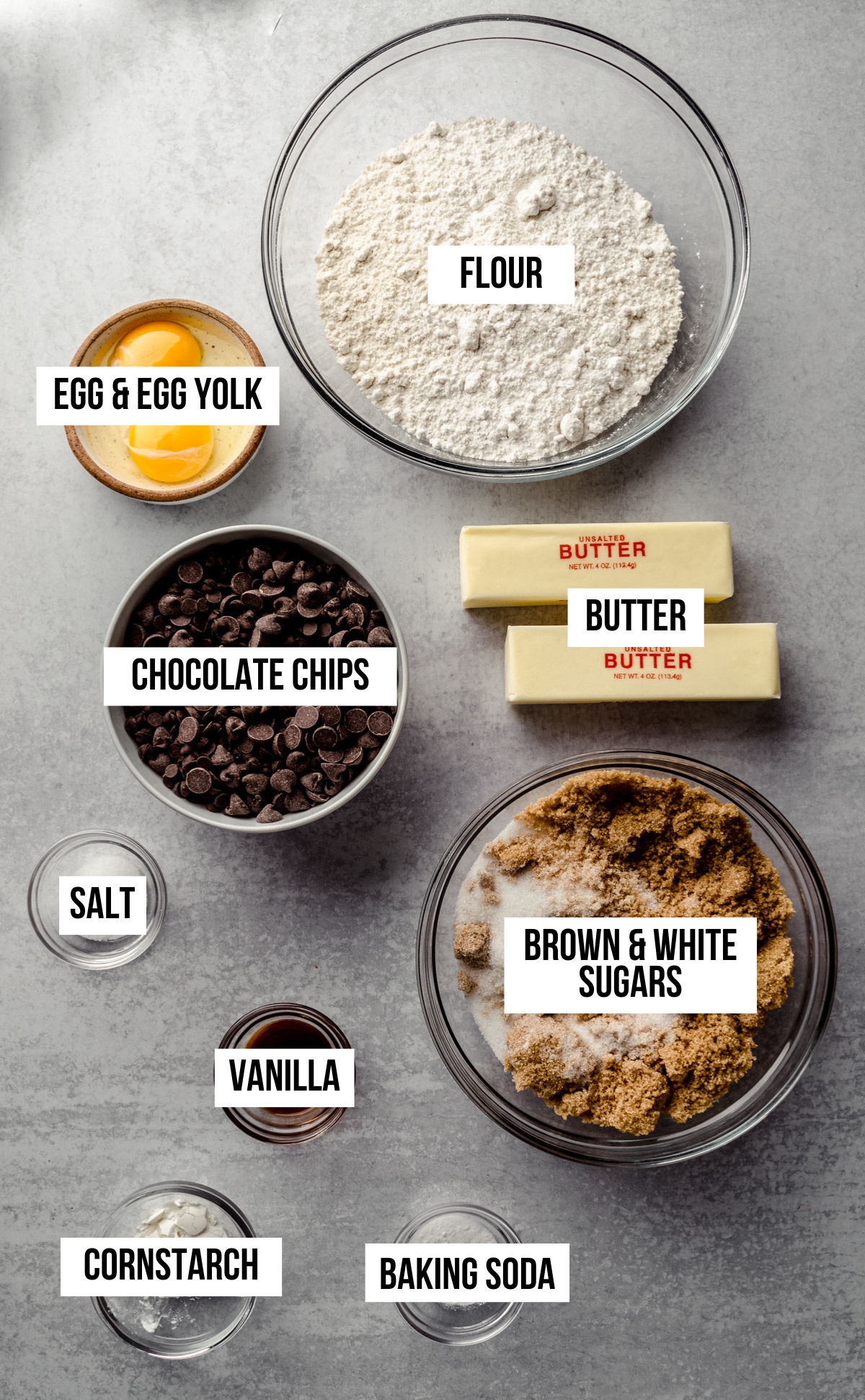 Aerial photo of ingredients to make brown butter chocolate chip cookies with text overlay labeling each ingredient. 