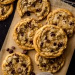 Aerial photo of brown butter chocolate chip cookies on a piece of parchment paper.