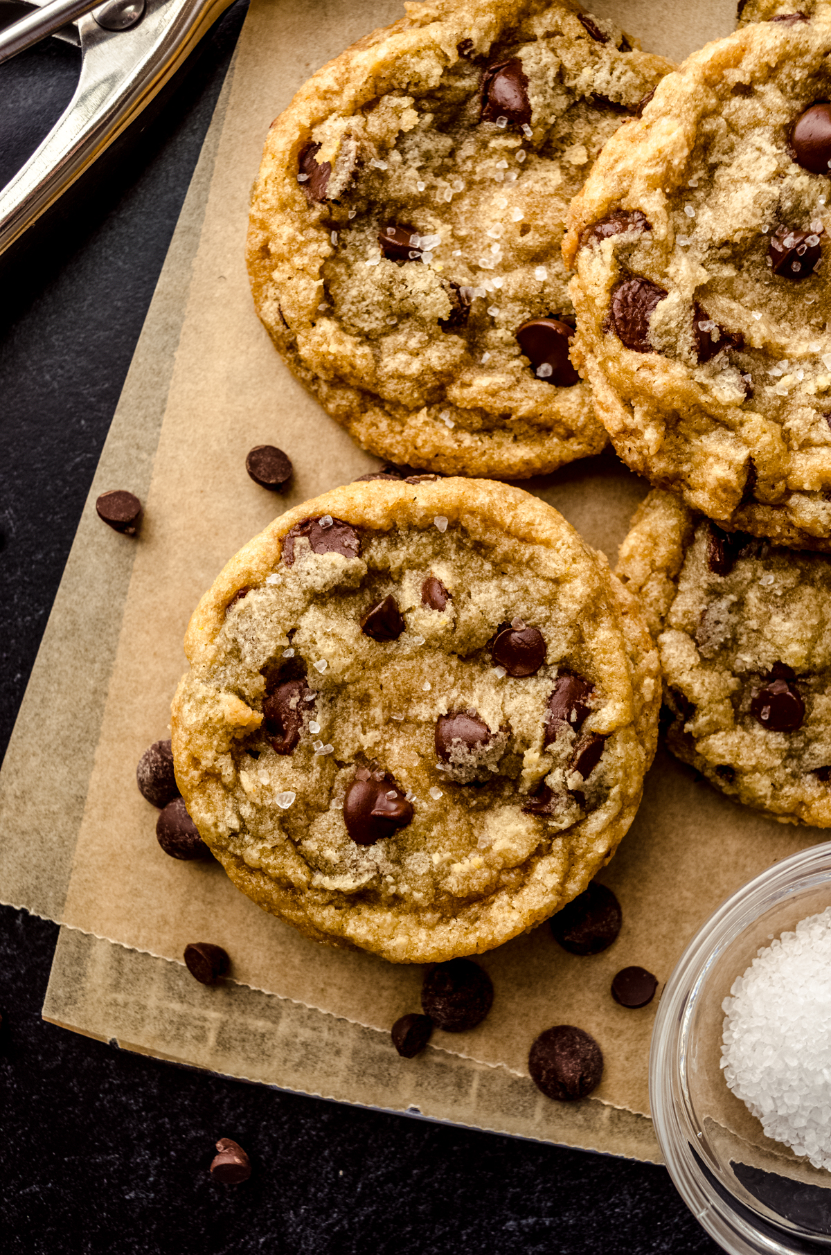 Aerial photo of brown butter chocolate chip cookies on a piece of parchment paper.