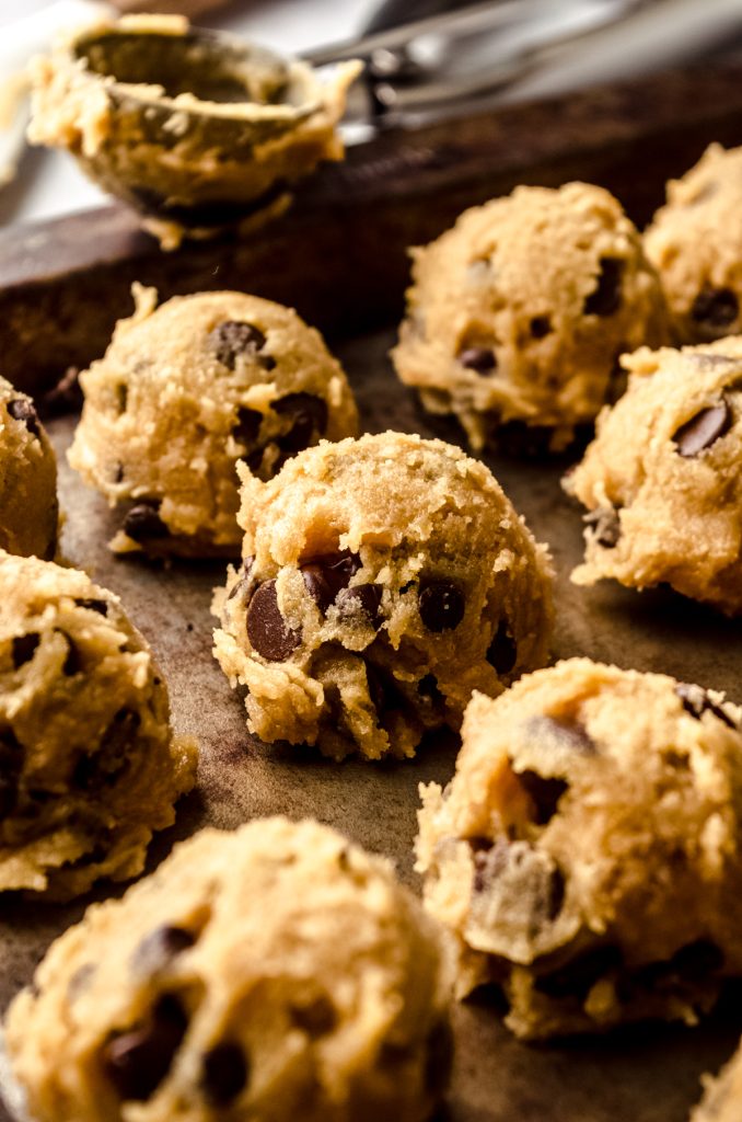 Balls of brown butter chocolate chip cookie dough on a baking sheet.