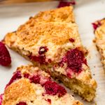 A raspberry white chocolate chip scone on a plate.