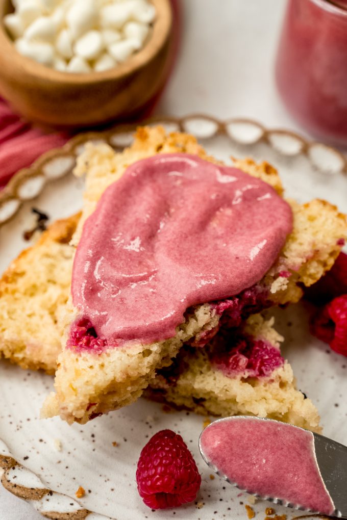 A raspberry white chocolate chip scone cut in half and spread with raspberry curd.