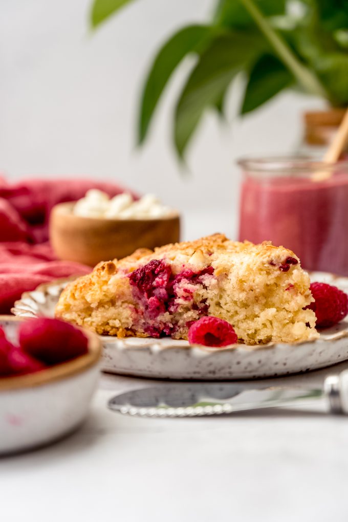 A raspberry white chocolate chip scone on a plate.
