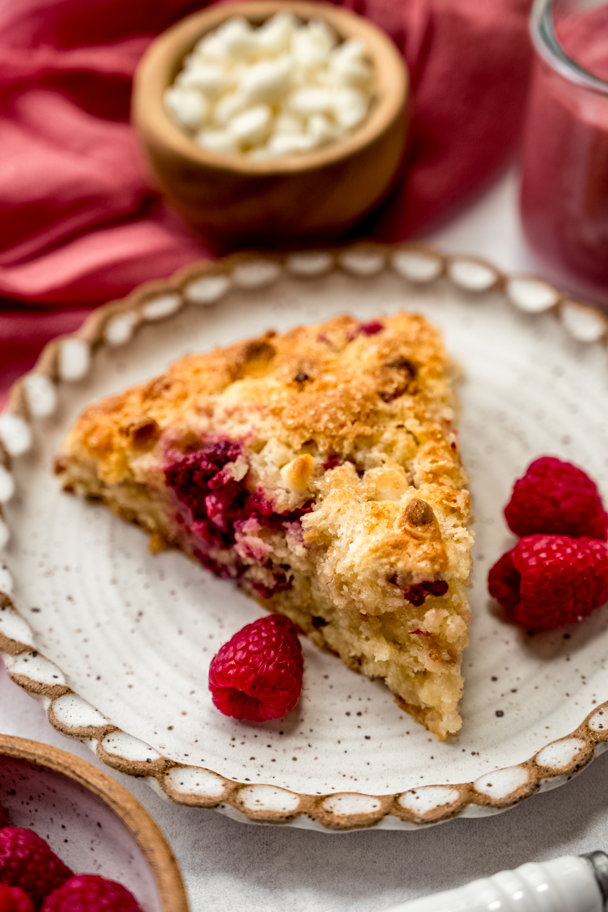 A raspberry white chocolate chip scone on a plate.