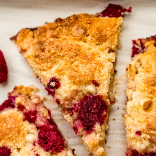 A raspberry white chocolate chip scone on a plate.