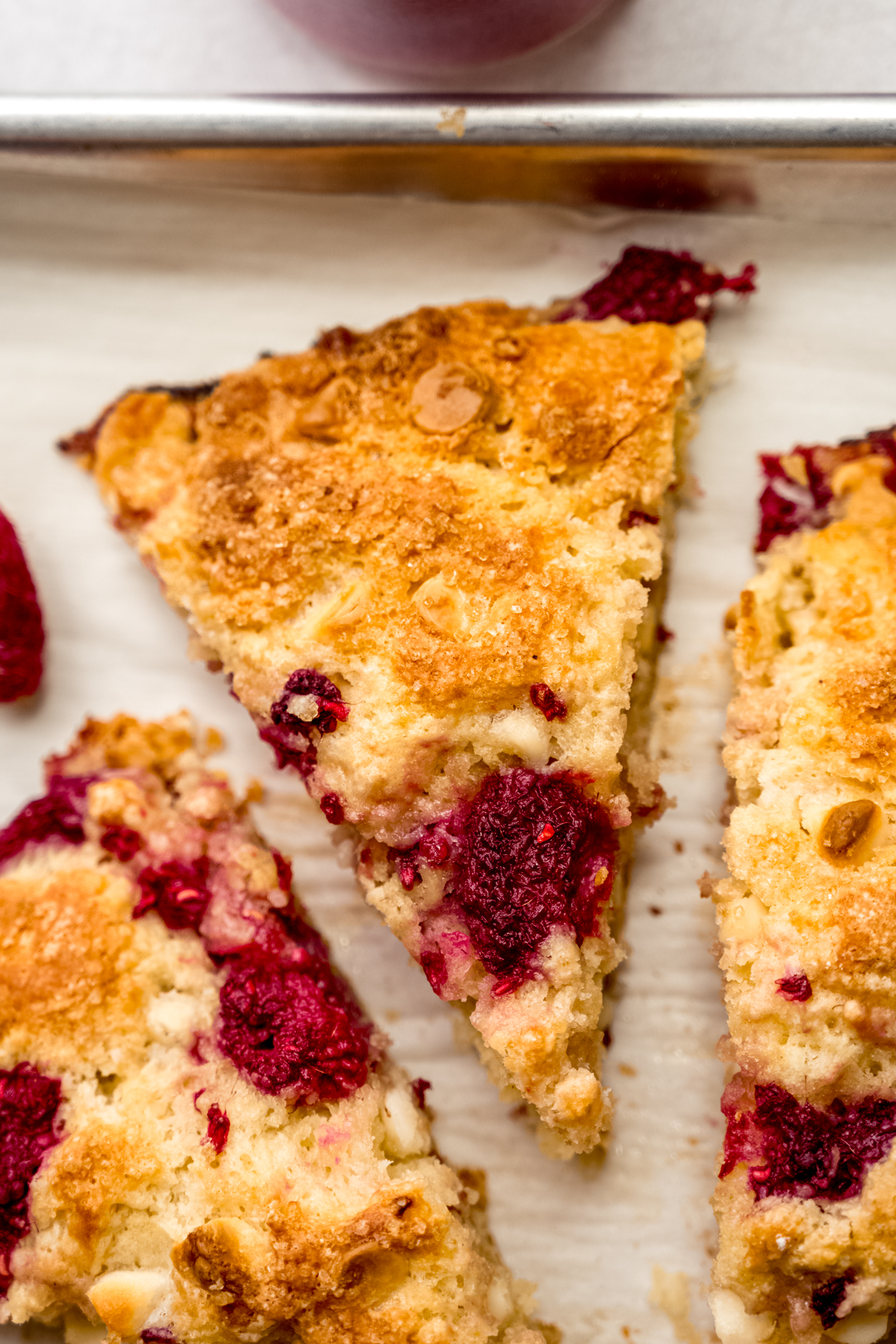 A raspberry white chocolate chip scone on a plate.