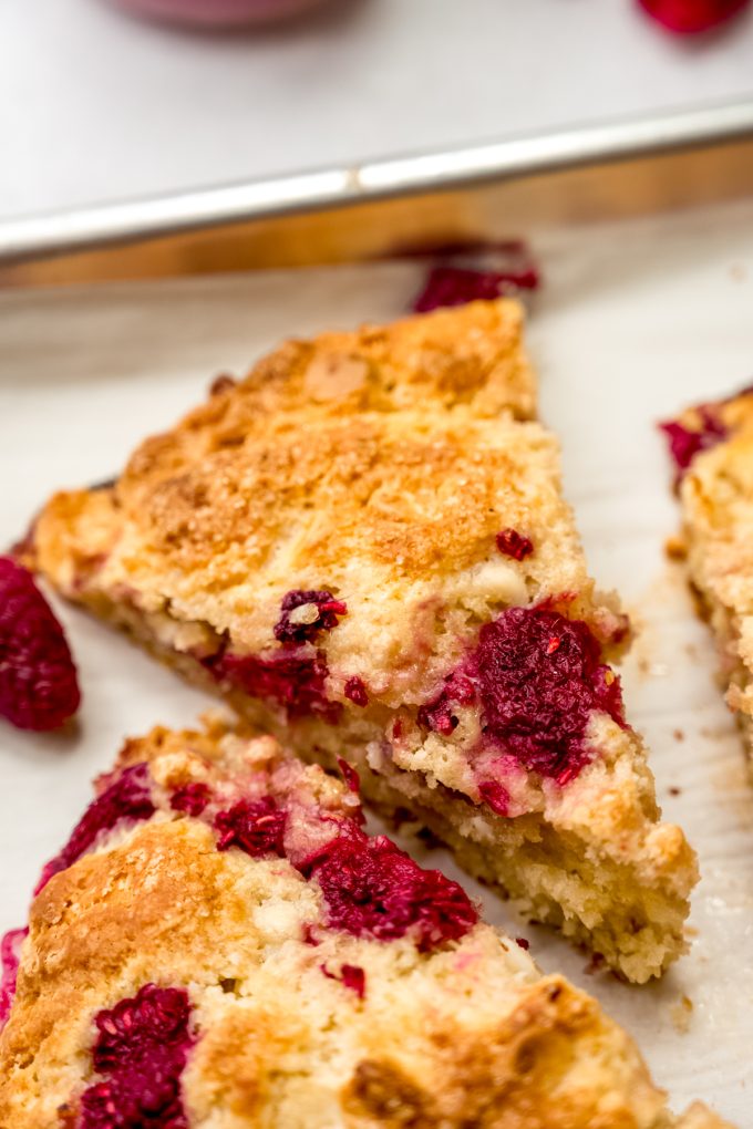 A raspberry white chocolate chip scone on a plate.