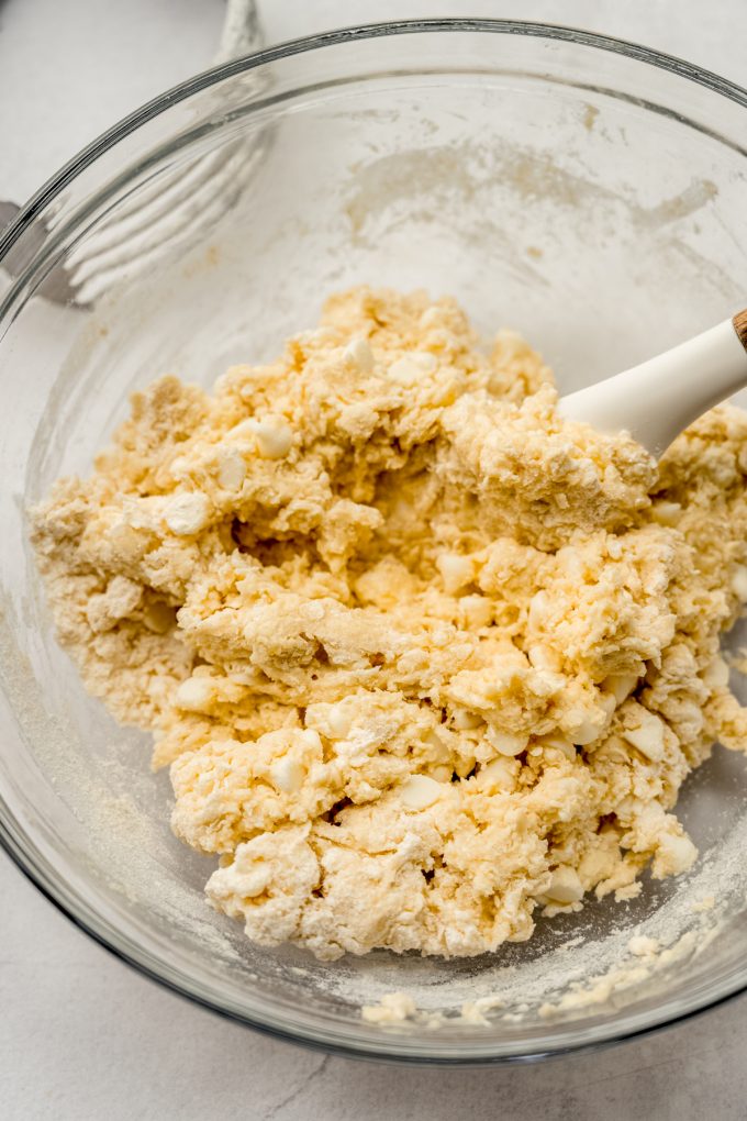 Scone dough coming together in a bowl with a large spatula.