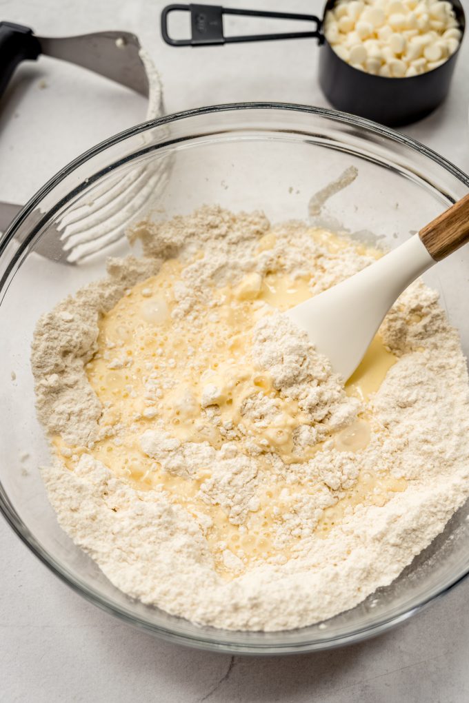 The dough for scones in a bowl with a spatula getting ready to stir in the wet ingredients.