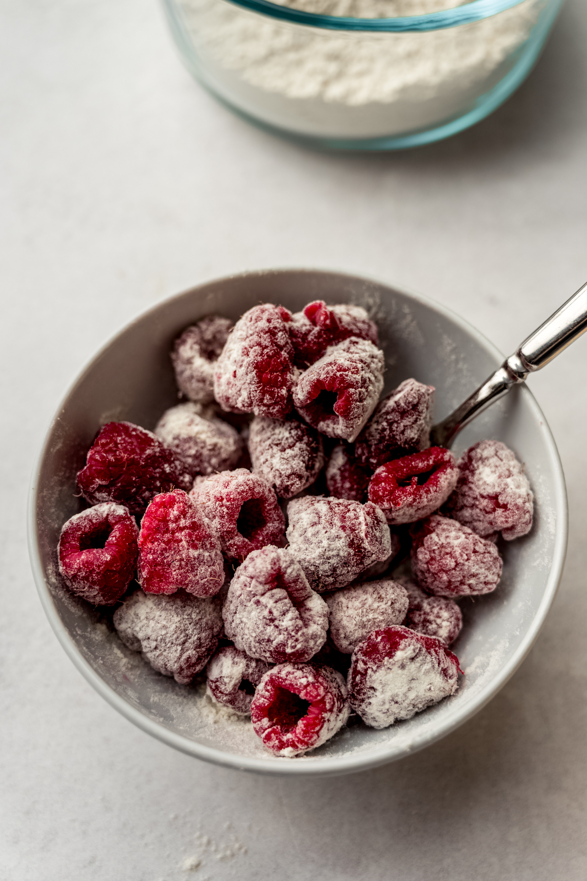 A bowl of raspberries tossed with flour.