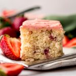 A slice of strawberry sheet cake on a plate with a fork.