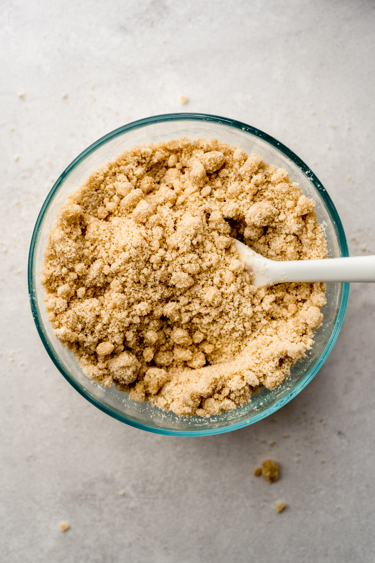 Aerial photo of a bowl of sandy crumb topping for banana cake.