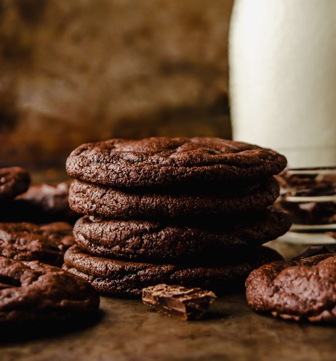 A stack of dark chocolate cookies on a surface.