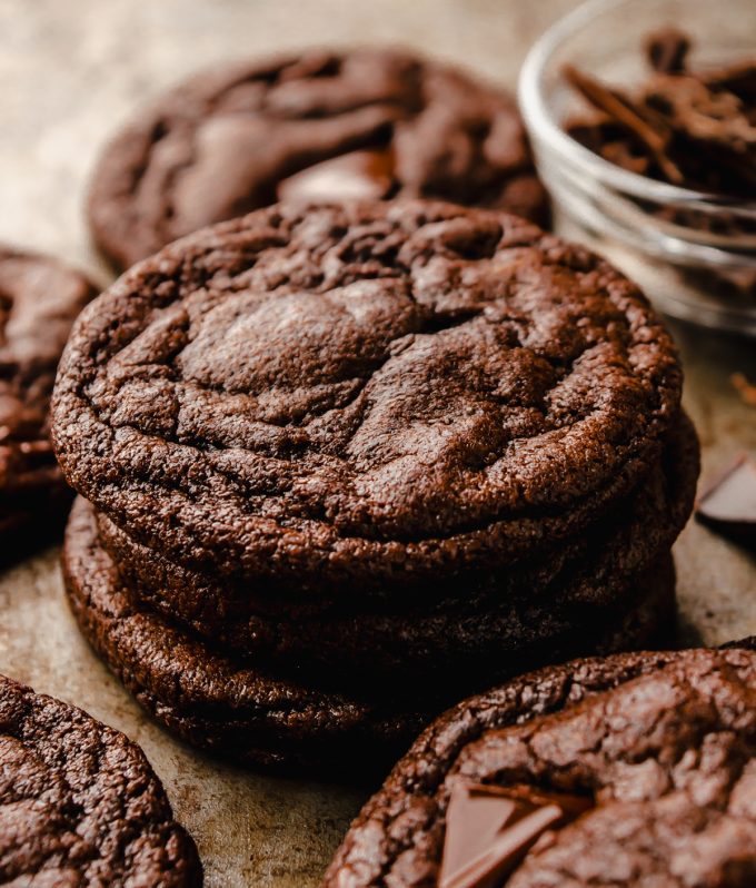 A stack of dark chocolate cookies on a surface.