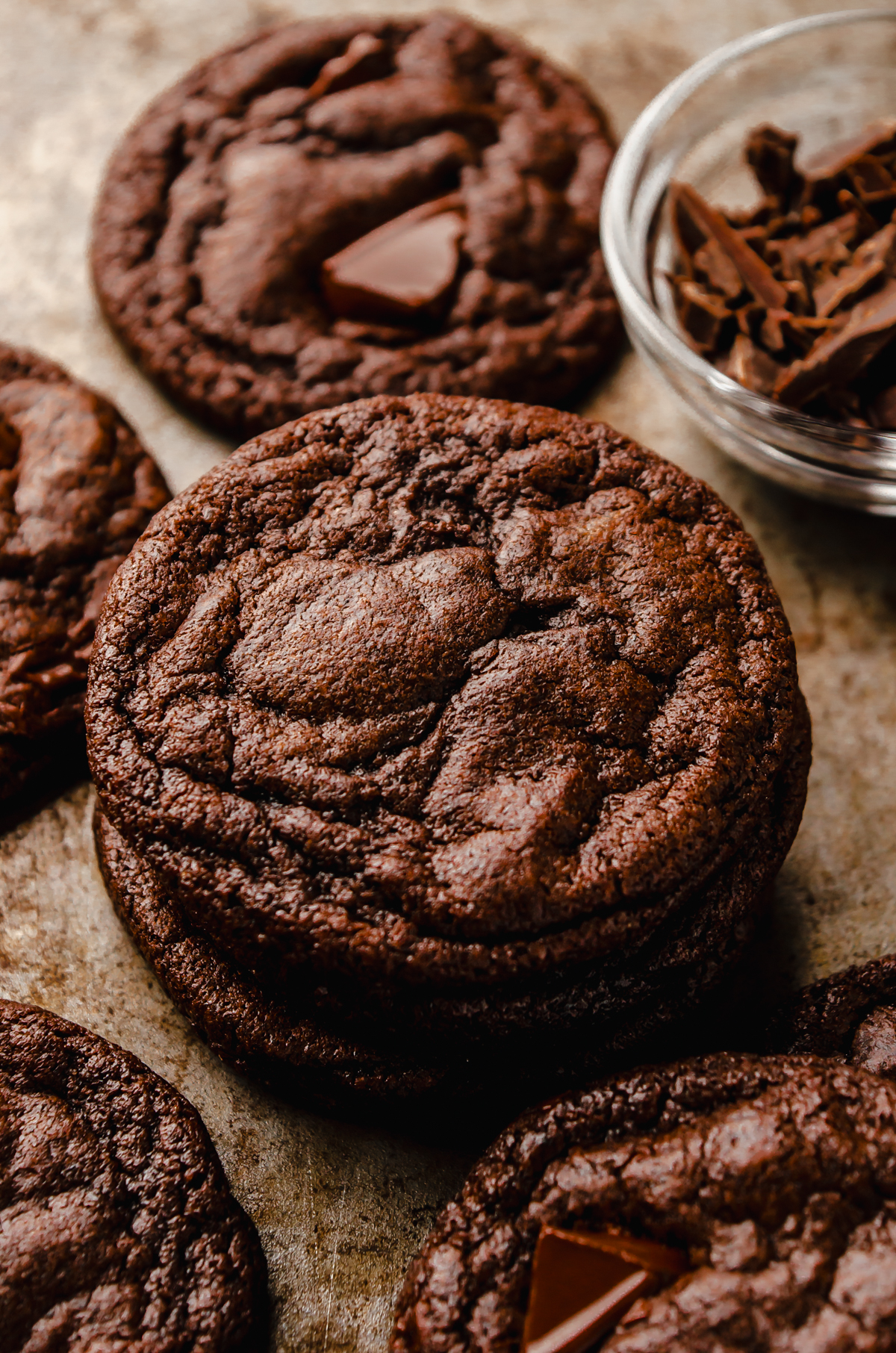 A stack of dark chocolate cookies on a surface.