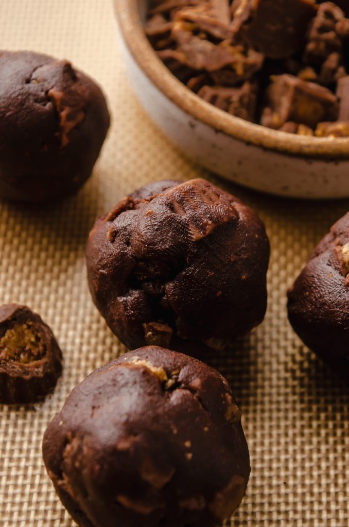 Chocolate peanut butter cup cookie dough balls on a baking sheet.