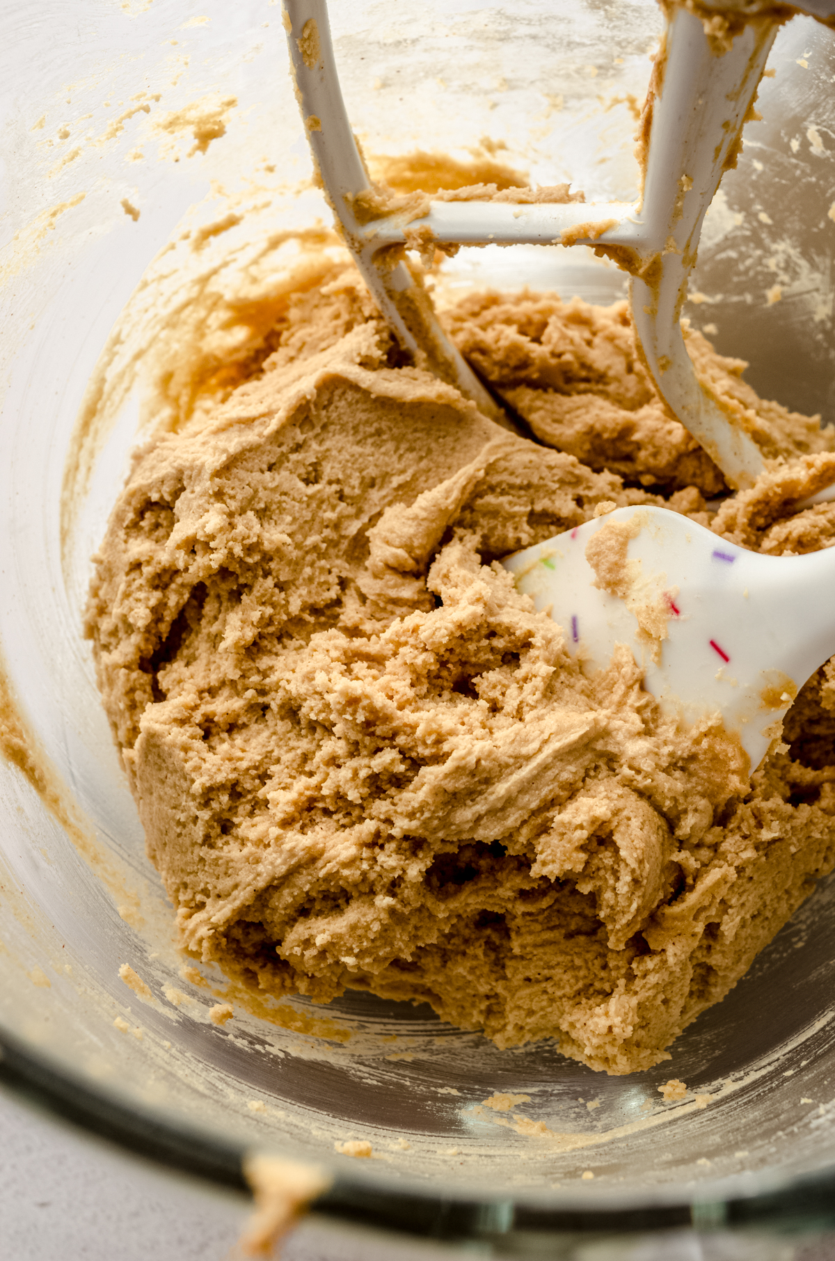 A bowl of classic peanut butter cookie dough with a spatula in it.