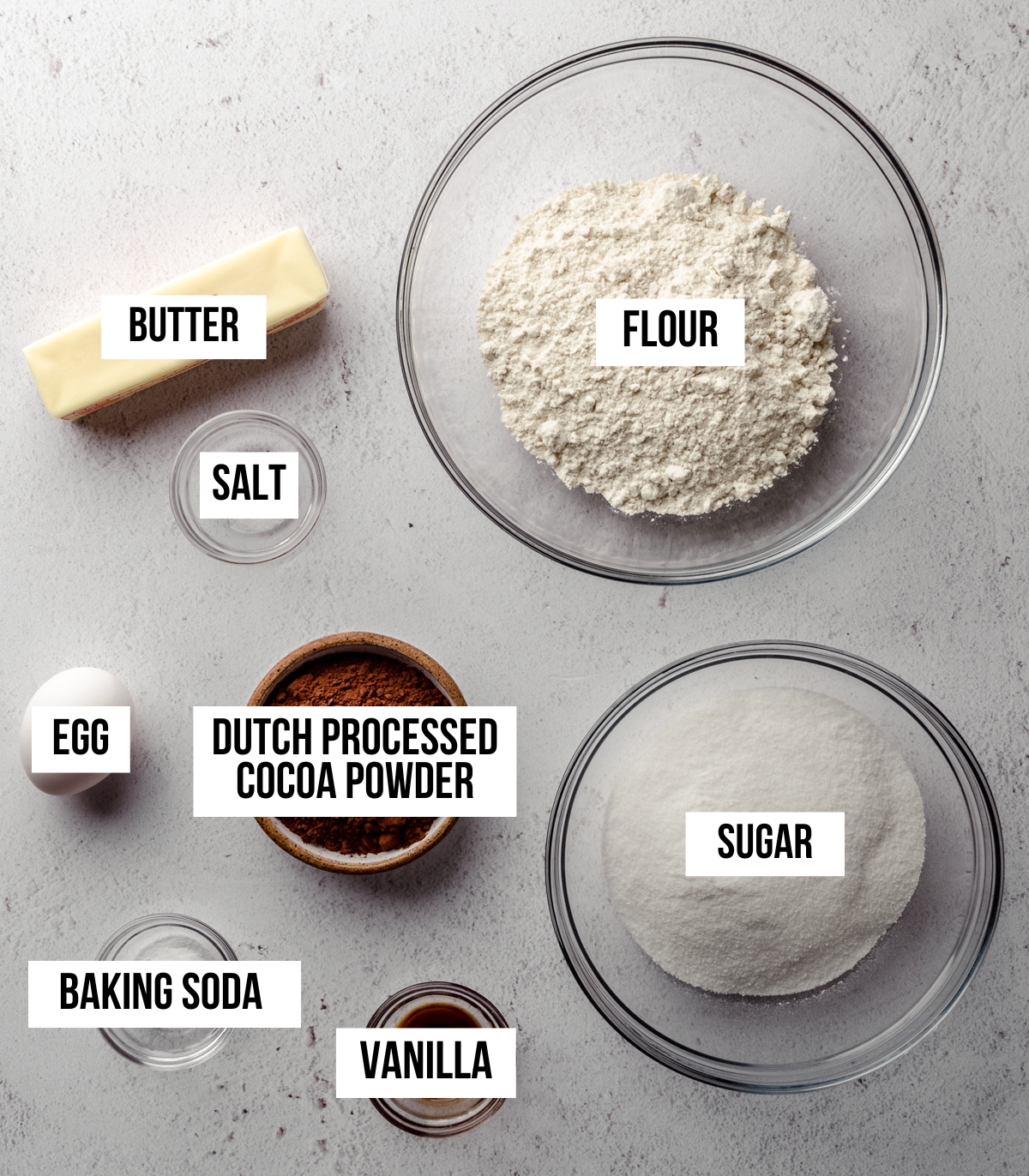 Aerial photo of ingredients to make dark chocolate cookies with text overlay labeling each ingredient.