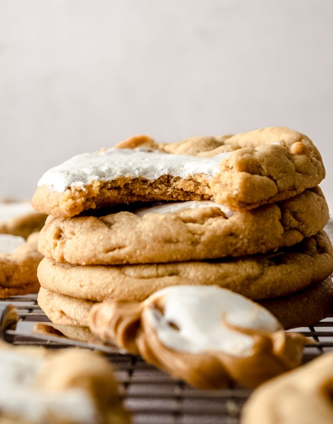 A stack of fluffernutter cookies on a cooling rack with a bite taken out of the one on top.